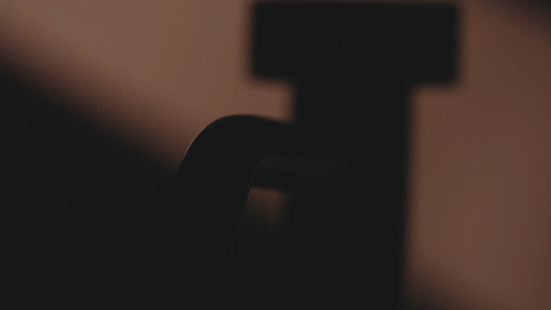 Cinematische, warm getinte close-up van een Bongio designkraan in silhouet